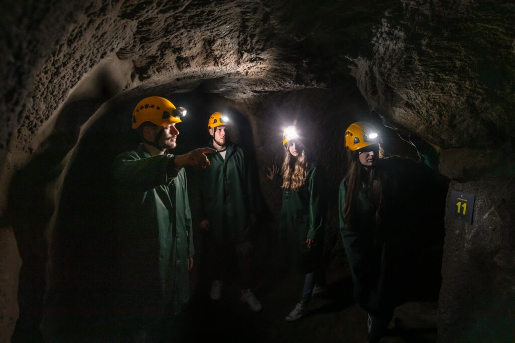 Four people with helmets on yellow helmets in the Znojmo underground